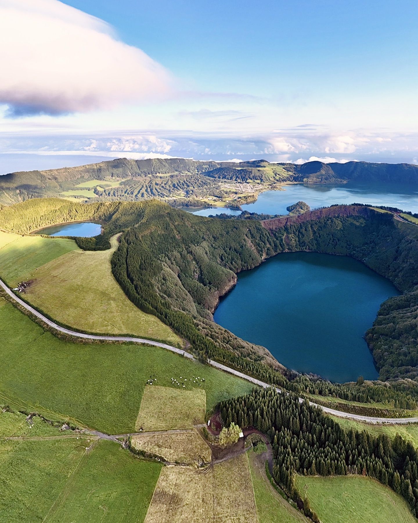 Two crater lakes ringed by green farmland